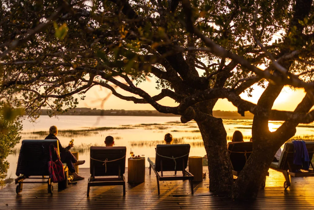 Guests watching sunset over Lake Shengeza from Kosi Forest Lodge