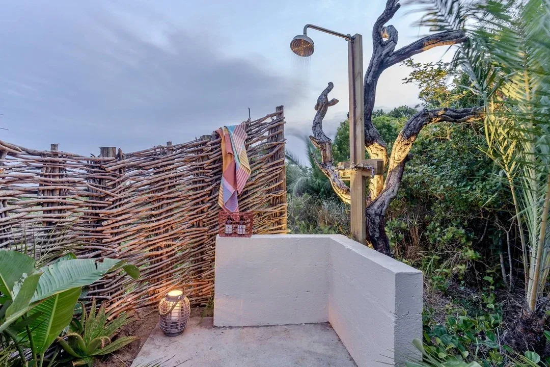 Outdoor shower surrounded by coastal vegetation at Big Skies Ubunye